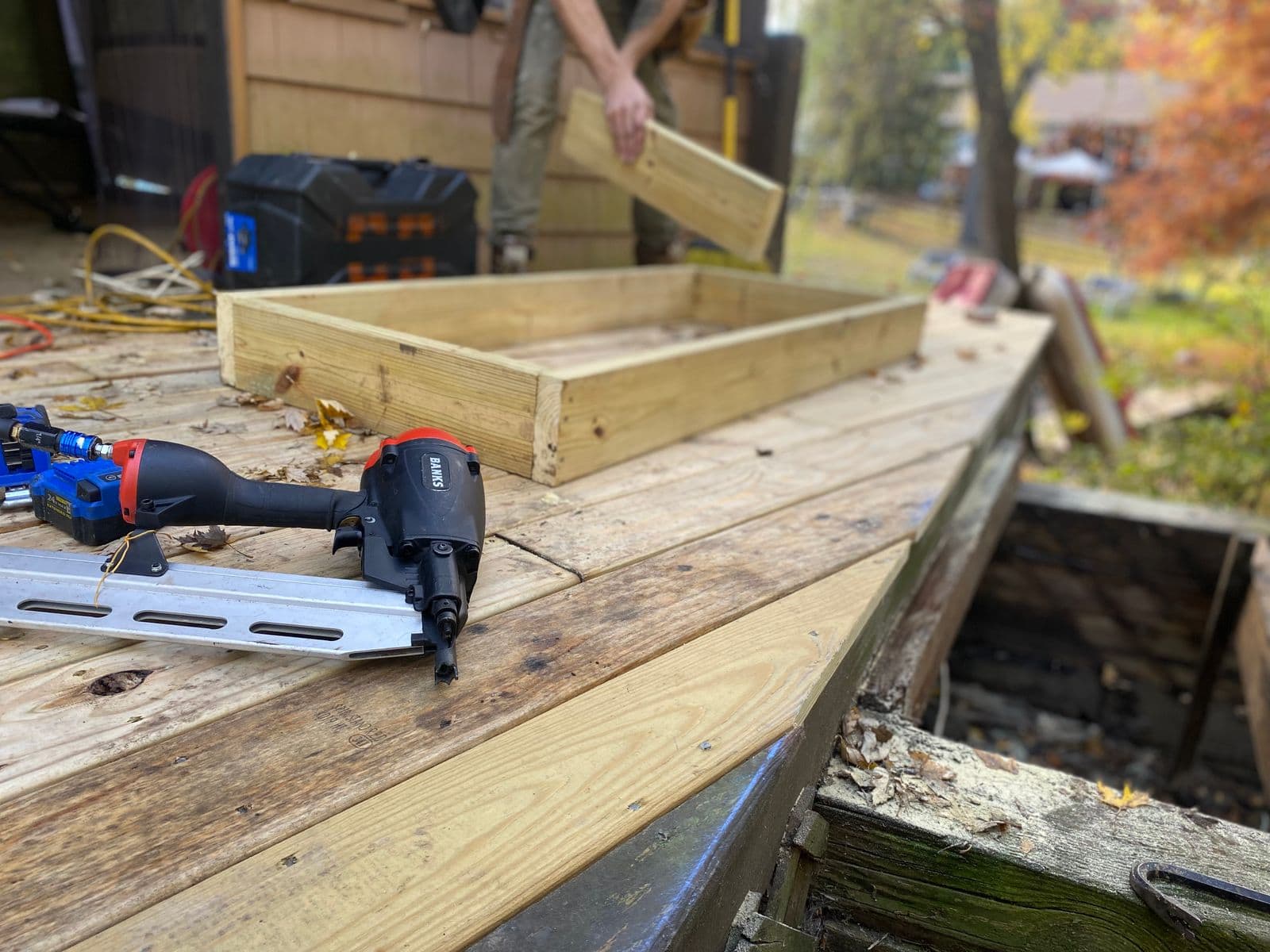 Nail gun and new framing on a deck under construction