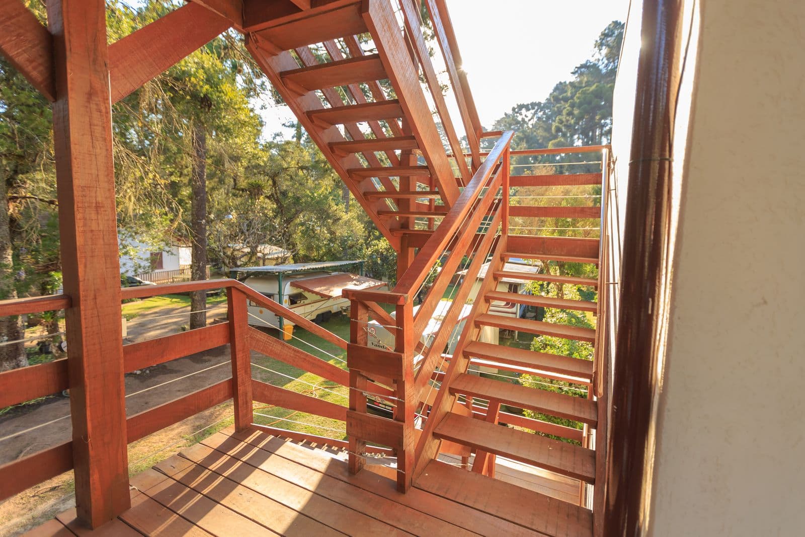 Wooden stairs and railings on a raised deck among trees